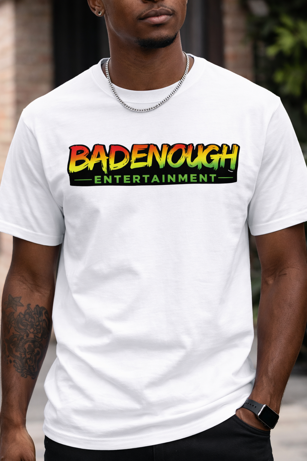 Person wearing a white t-shirt with 'BADENOUGH ENTERTAINMENT' printed on it.
