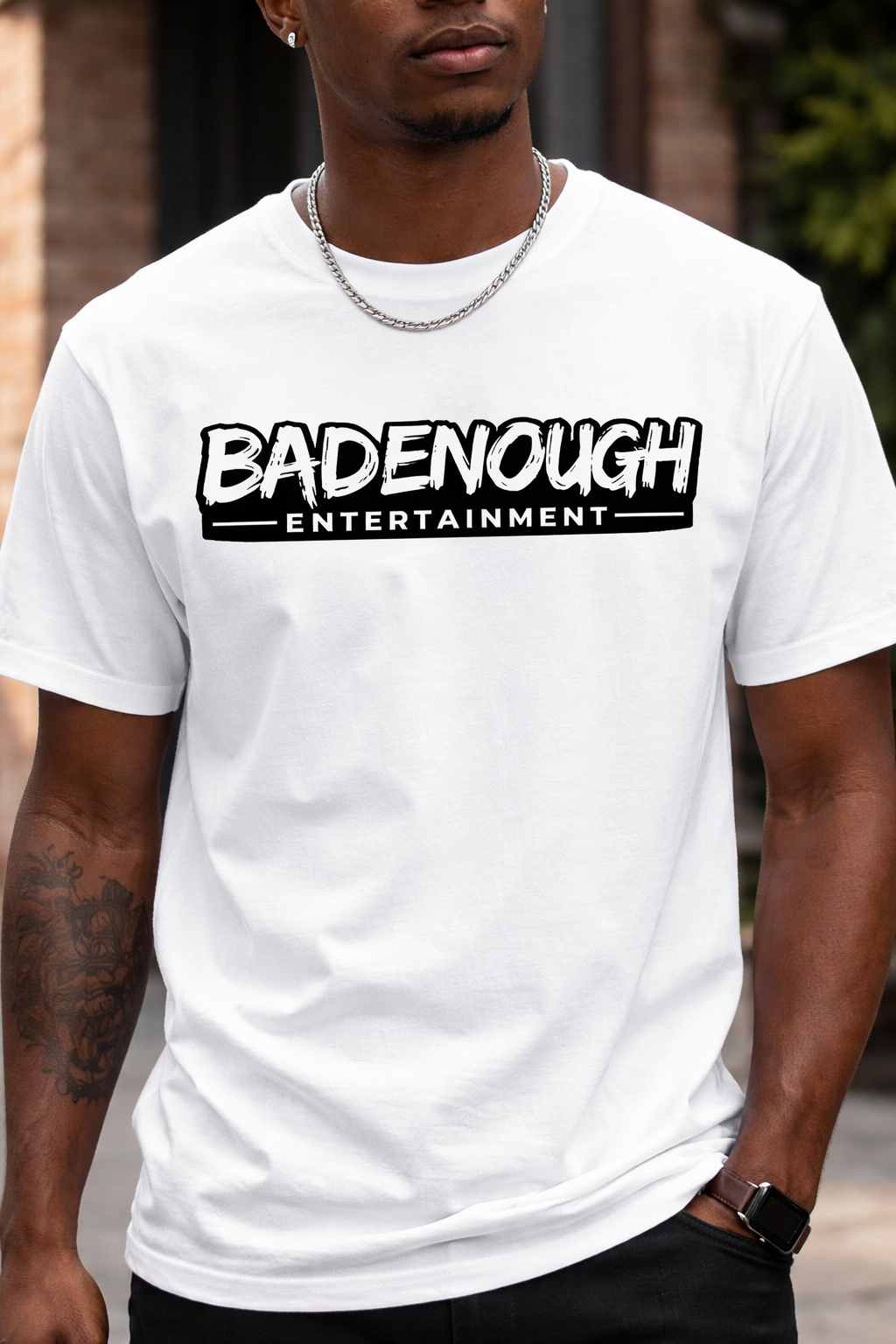 Person wearing a white t-shirt with 'BADENOUGH ENTERTAINMENT' text.